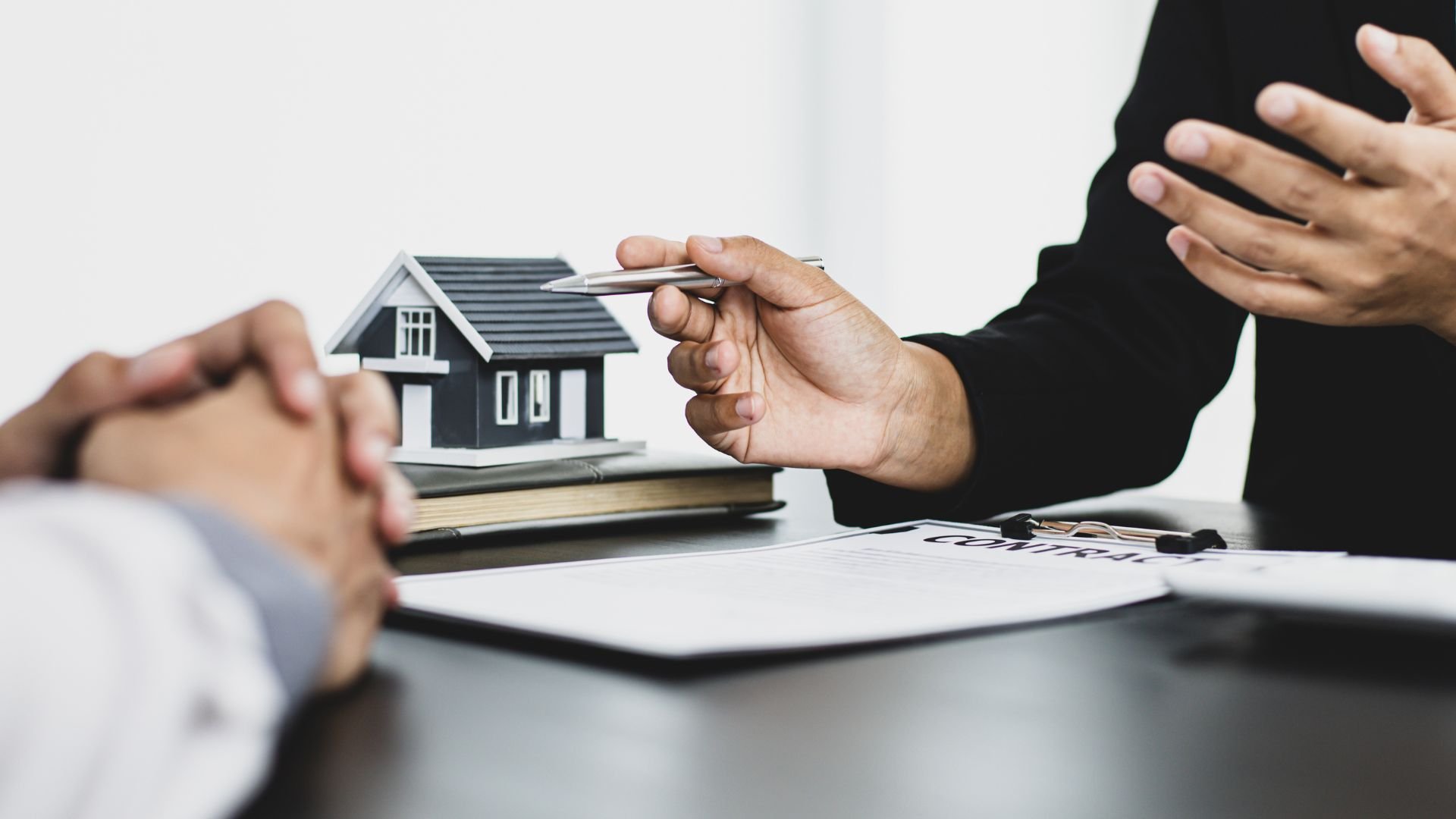 Real estate agent discussing home purchase with miniature house model